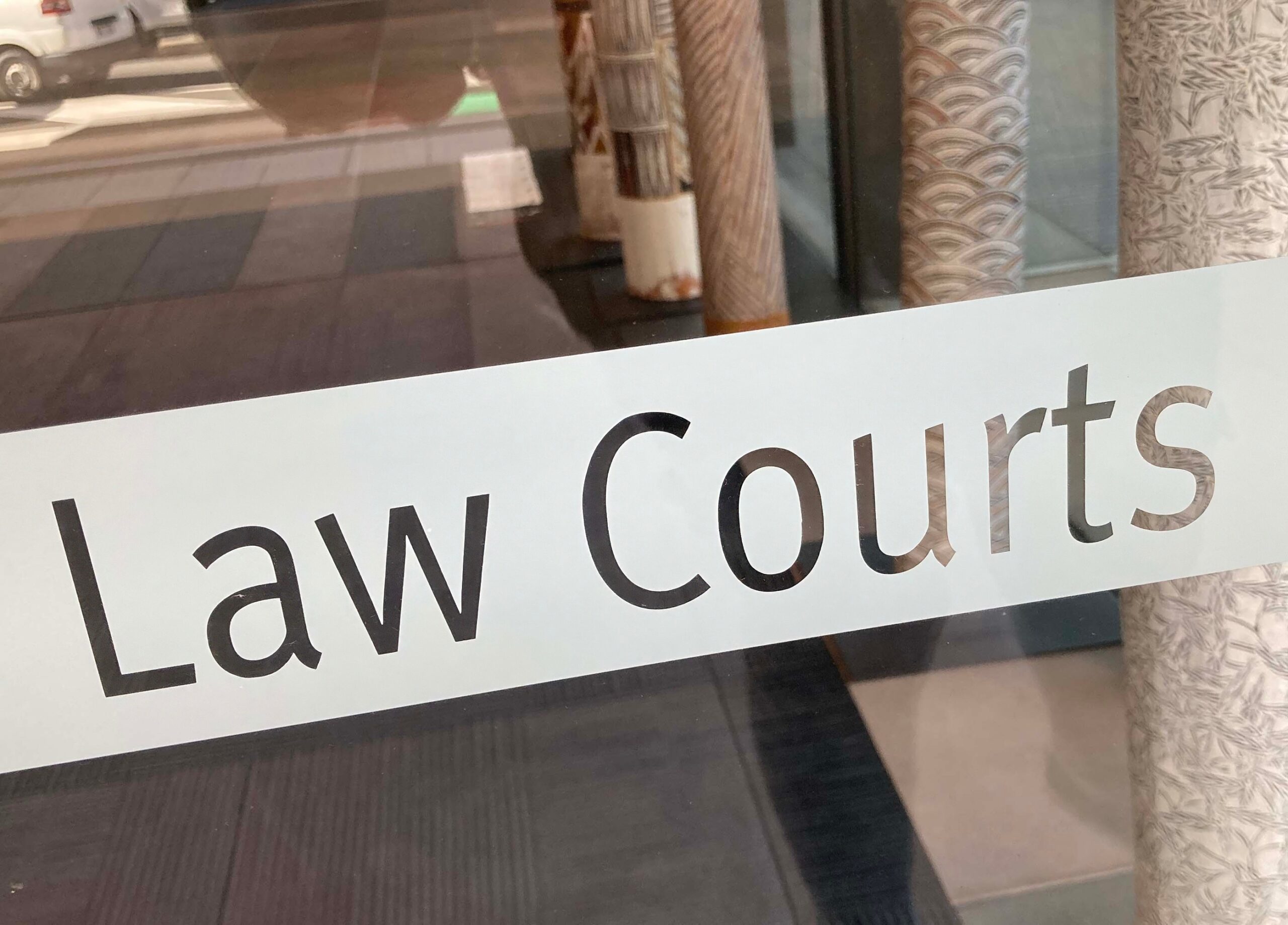 Signage reading "Law Courts" on a glass door